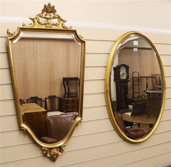 A plain oval gilt framed mirror and a shield shaped gilt frame mirror, H.92cm and H.108cm